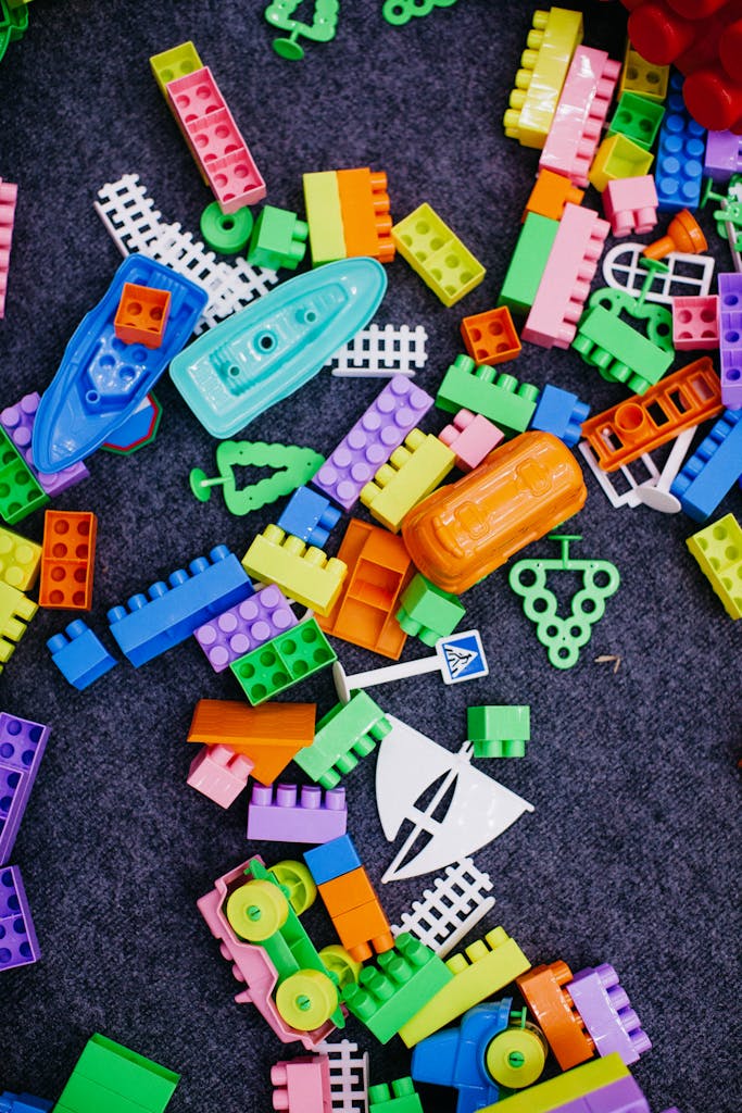 Vibrant toy building blocks and shapes scattered on a carpet, perfect for children's play.