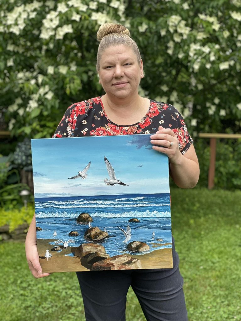 Artist holding one of her art works