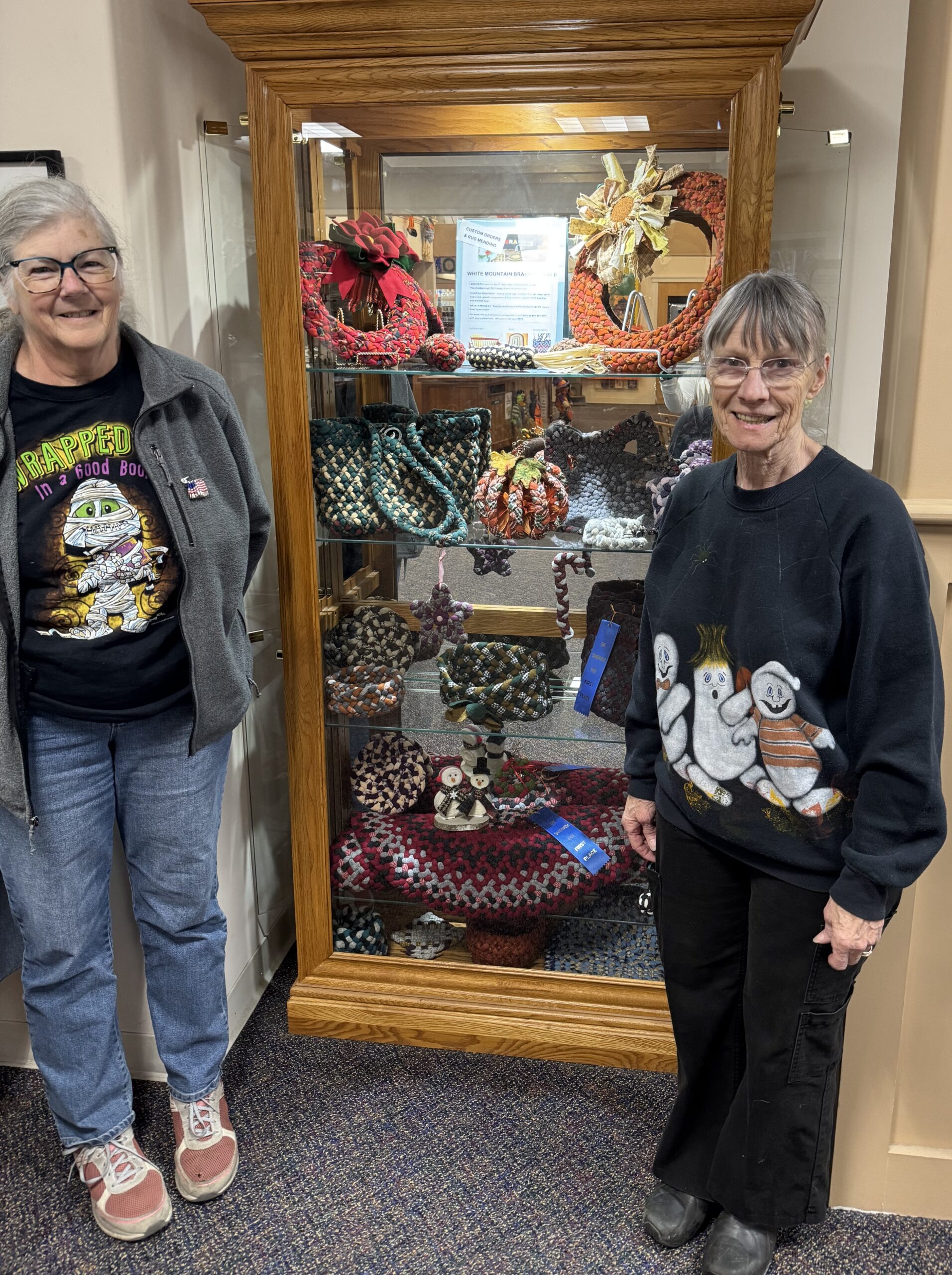 Library display case filled with braided rug items