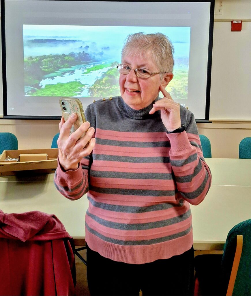 Woman points to her hearing device as she tests the ADA compliant sound system at the library.